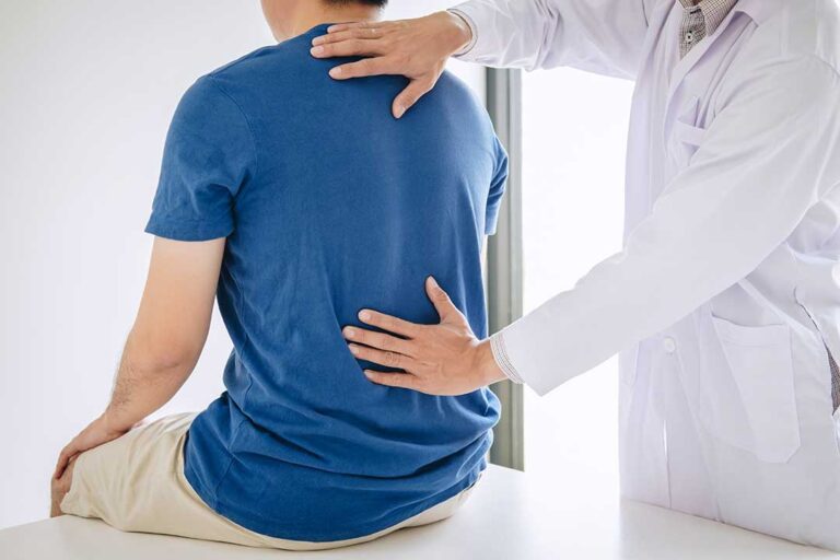 A person rotating their arm in a gentle circle, demonstrating a shoulder mobility exercise indoors.