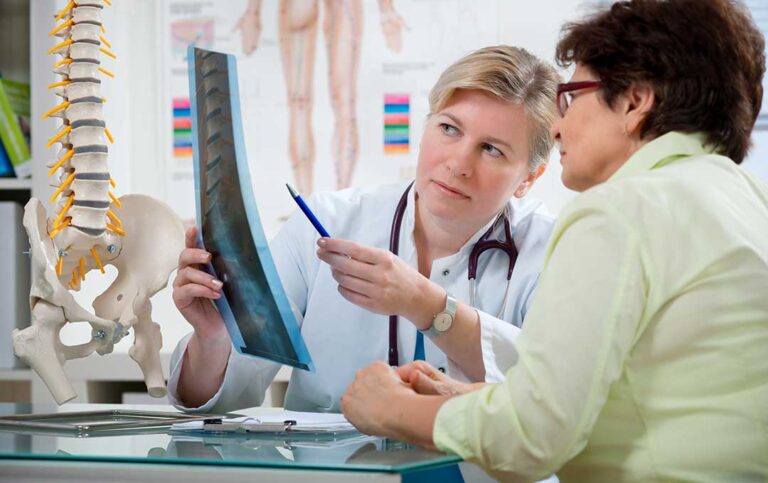 Person adjusting desk posture while seated upright with relaxed shoulders and feet supported.